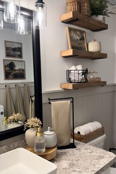 a bathroom with two shelves above the toilet