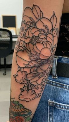 a woman's arm with flowers on it, and a bird in the middle