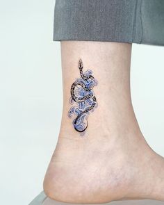 a woman's foot with a tattoo design on the side of her leg,