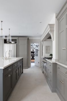 a large kitchen with gray cabinets and white counter tops