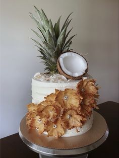 there is a cake that has been decorated with flowers and a pineapple on top