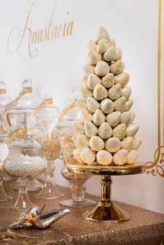 a table topped with lots of different types of desserts and candies on top of each other