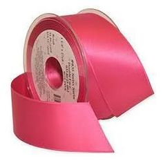 a roll of pink satin ribbon on a white background