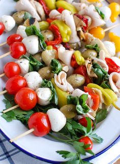 a white plate topped with skewered vegetables and veggies