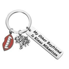 a metal keychain with an image of a kiss on the lips and words