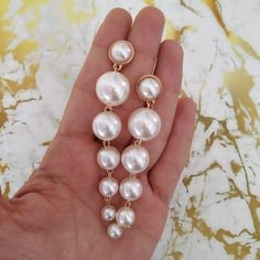 a person holding some pearls in their hand