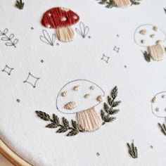 a close up of a cross stitch pattern with mushrooms and leaves on the embroiderying