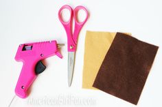 a pair of pink scissors sitting next to a piece of felt