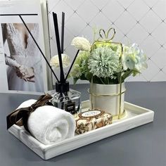 a white tray with flowers and candles on it