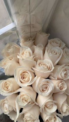 a bouquet of white roses sitting on top of a table