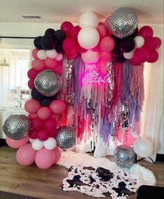 a room with balloons, disco balls and streamers