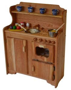 an old fashioned wooden toy stove with pots and pans on it's shelf