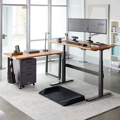 a desk with a computer monitor and keyboard on it in front of a bookshelf