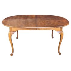 an oval wooden table with two leaves on it