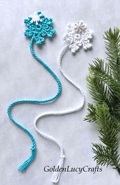 three crocheted snowflakes are shown next to a pine tree