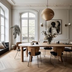 an elegant dining room with wood floors and white walls