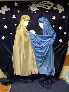 two mannequins dressed in blue and beige are standing next to each other