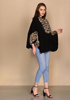 This black collared cape is knitted from a very soft fine wool and is one of a kind. Its uniqueness is in its versatility with the many ways that it can be styled. But that's not all it has contrasting leopard fur applications on the bust and sleeves that makes it a head-turner. Classy stylish and comfortably warm. Chic Black Wool Cape, Oversized Black Winter Cape, Chic Oversized Cashmere Cape, Chic Black Turtleneck Outerwear, Chic Black Capelet, Black Batwing Sleeve Sweater For Layering, Black Wool Poncho For Fall, Wool Black Poncho For Fall, Black Knit Sweater With Batwing Sleeves