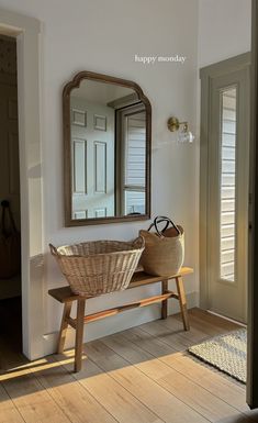 a basket sitting on top of a wooden bench in front of a mirror and door