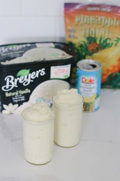 two glasses filled with yogurt sitting on top of a table next to other items