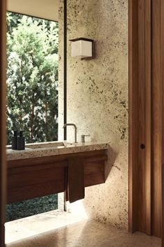 a bathroom sink sitting under a mirror next to a wooden door