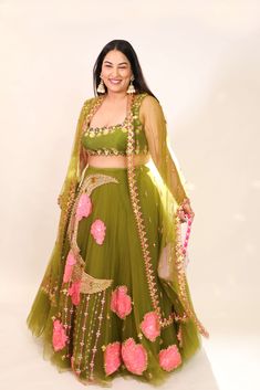 Introducing a tulle lehenga in olive, adorned with glass beads, metals, sequins, and 3D embroidered flowers. Paired elegantly with an olive raw silk blouse embellished with shell stones, crystals, and metals, along with a complementing tulle dupatta. This ensemble combines intricate detailing with a touch of glamour for a captivating look. Tulle Lehenga, Raw Silk Blouse, Lehenga Blouse Designs, Embroidered Lehenga, Lehenga Blouse, Indian Design, Raw Silk, Green Fabric, Handmade Clothes