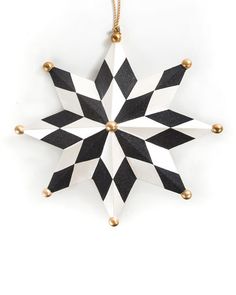 a black and white star ornament hanging from a gold - plated chain