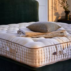 an old mattress is laying on top of it's frame in front of a green headboard