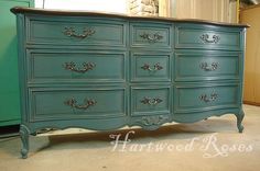 an old dresser is painted blue and has ornate handles