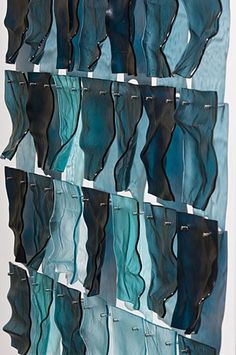 blue and black glass pieces hanging on a wall