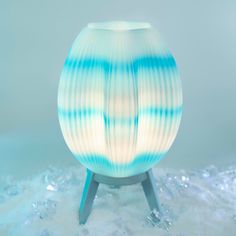 a blue and white vase sitting on top of a wooden stand with ice around it