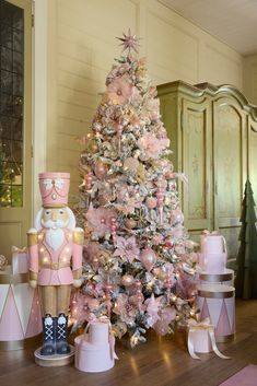 a pink and gold christmas tree with decorations