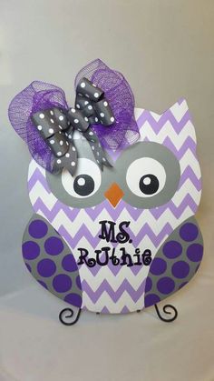 an owl with purple and white polka dots on it's head is sitting in front of a sign that says mrs rouhe