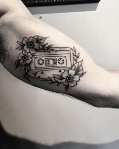 a man's arm with an old school style cassette tattoo on the left forearm