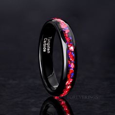 a black ring with red and blue flowers inlayed to it's surface