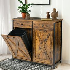 a wooden cabinet with two trash cans and a potted plant