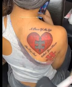 a woman with a heart shaped puzzle tattoo on her shoulder