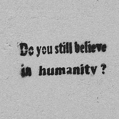 the words do you still believe in humanity? written on a concrete wall with black ink