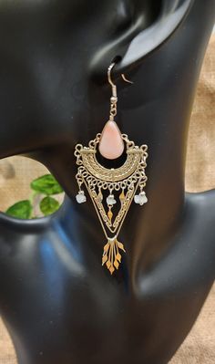 These beautiful, Peruvian, handmade earrings are just what you've been looking for. They have pink onyx and quartz gemstones in metal settings and dangle so elegantly in the wind. The design is so intricate, yet simple and only adds to the detailing of the earrings. They measure approximately 4" long x 1.25" wide. These are handmade and used, thus will have variations throughout and some noticeable wear, but they are otherwise absolutely beautiful. Bohemian Teardrop Earrings With Natural Stones, Bohemian Long Drop Chandelier Earrings Nickel Free, Pink Metal Jewelry With Dangling Beads, Bohemian Long Drop Nickel-free Chandelier Earrings, Bohemian Nickel-free Long Drop Chandelier Earrings, Pink Rose Quartz Earrings With Natural Stones, Bohemian Gold Rose Quartz Jewelry, Elegant Long Drop Earrings For Festivals, Nickel Free Bohemian Long Drop Earrings