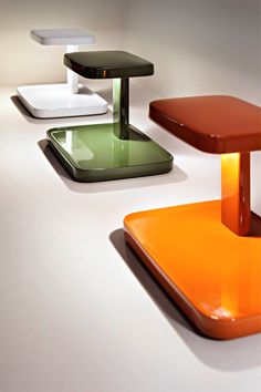 four different colored tables and stools on a white table with light coming from the top