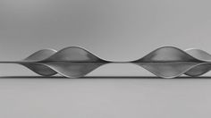 an abstract metal object with wavy lines on the top and bottom, against a gray background