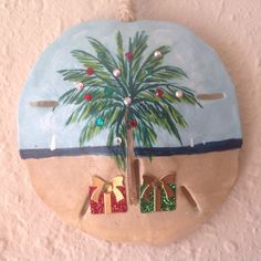 a ceramic ornament hanging from the side of a wall with shoes and a palm tree painted on it