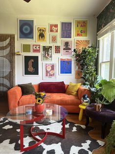 a living room filled with furniture and lots of pictures on the wall above it's coffee table