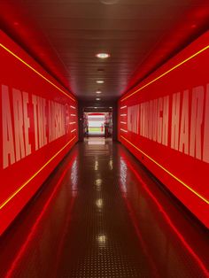 a long hallway with red walls and white lettering on the wall that says are there going hard?