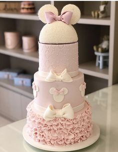 a three tiered cake with minnie mouse ears on top