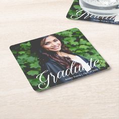 two square coasters with the words graduate and an image of a smiling woman on them