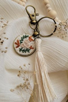 a keychain with a tassel hanging from it's side on top of a white cloth