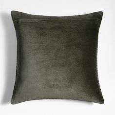 a dark green velvet pillow on a white background