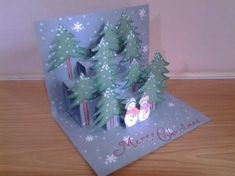 a christmas card with snowmen and trees