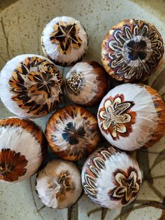 an arrangement of different types of mushrooms in a bowl on a table with brown and white designs